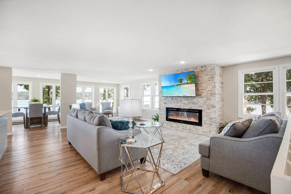A cozy living room with a plush seating area, inviting fireplace, large windows, and a television. The space is designed for relaxation, entertainment, and enjoying scenic views, evoking comfort and security.