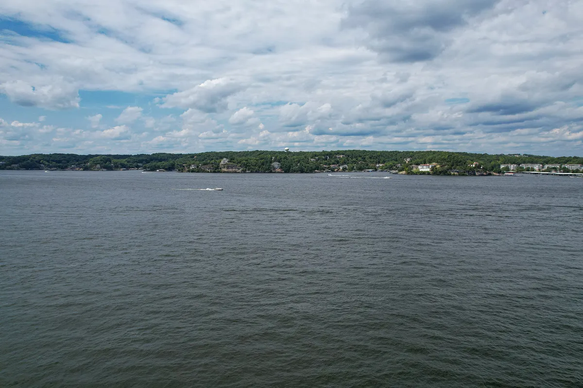 A wide, tranquil view of the lake, with an expansive water body, distant shoreline, and serene sky. The natural beauty sets the stage for outdoor activities and relaxation, capturing the essence of lake life and the tailored experiences available to guests through the LakeDays by Design™ program.